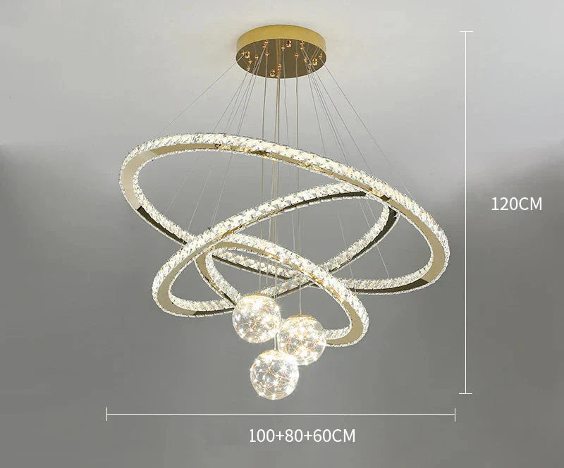 Three overlapping gold LED rings and four glass balls suspended from a gold mount, 120cm tall.