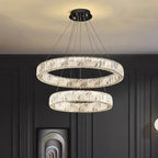 Contemporary chandelier with two illuminated crystal glass rings, suspended at different heights from a black mount.