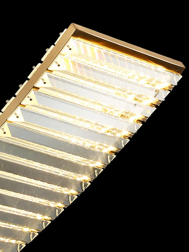 Close-up of Maison Ornate Gold Crystal Chandelier with angular glass panels and glowing LED lights.