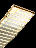 Close-up of Maison Ornate Gold Crystal Chandelier with angular glass panels and glowing LED lights.