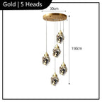 Modern gold-base chandelier with five crystal LED lamps hanging at different heights, 30cm by 150cm.
