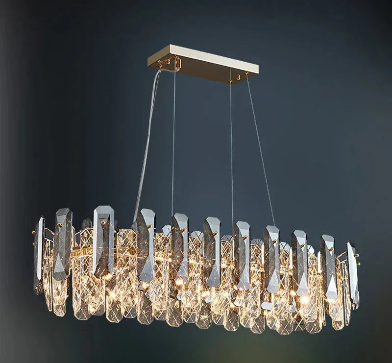 Gold frame chandelier with modern crystal prisms, rectangular mount, and warm LED illumination.