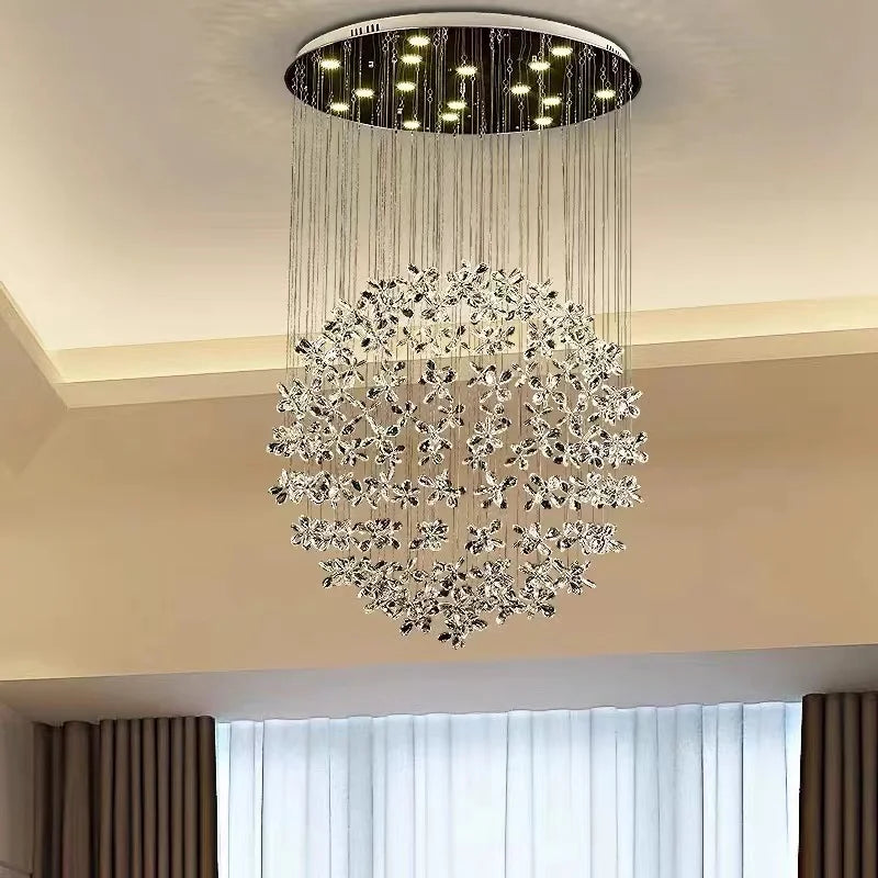 Ornate circular chandelier with hanging crystal-like ornaments on fine wires, emits elegant sparkling light.