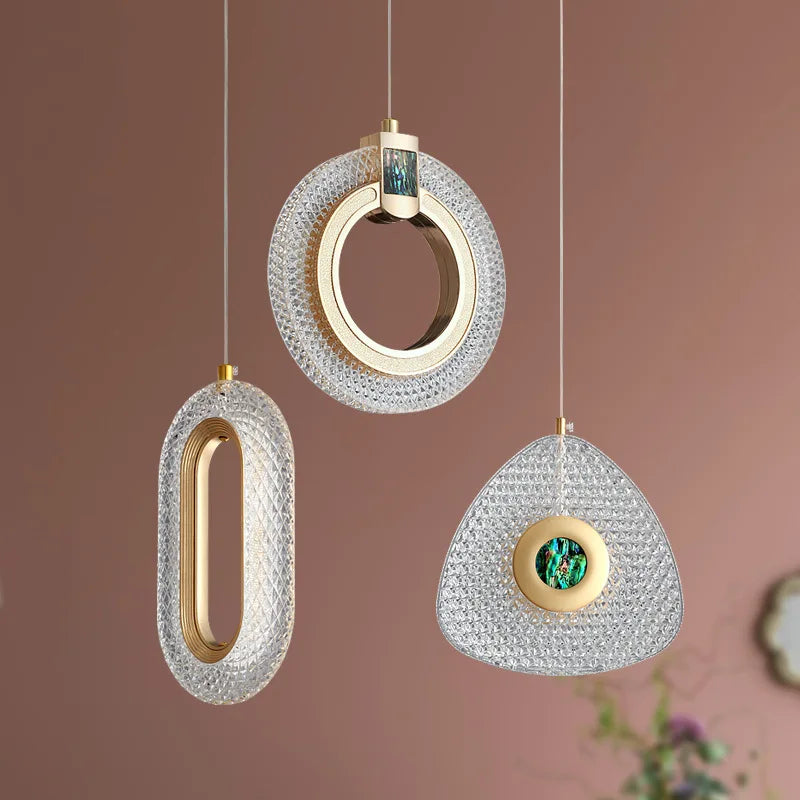 Set of three ornate Art Deco chandeliers with gold and emerald accents in oval, circular, triangular shapes.