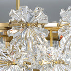 Ornate brass chandelier with crystal-like glass flowers and gold accents, elegant and sparkling.