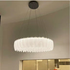 Ornate crystal ball chandelier with decorative feathers and glass, elegantly suspended by thin cables.