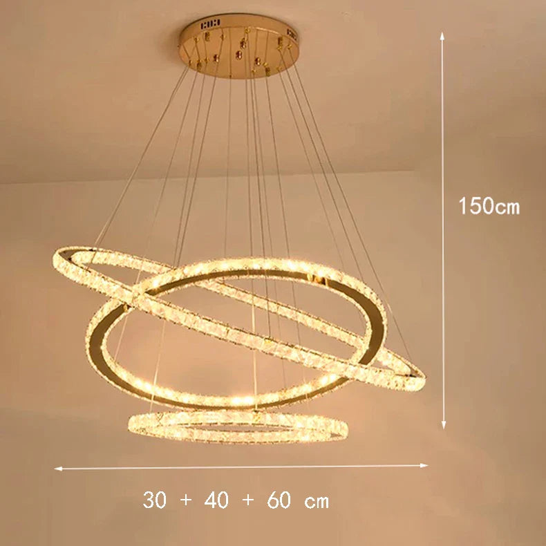 Three gold, ring-shaped LED chandelier lights in varying sizes, arranged at different orbital angles.