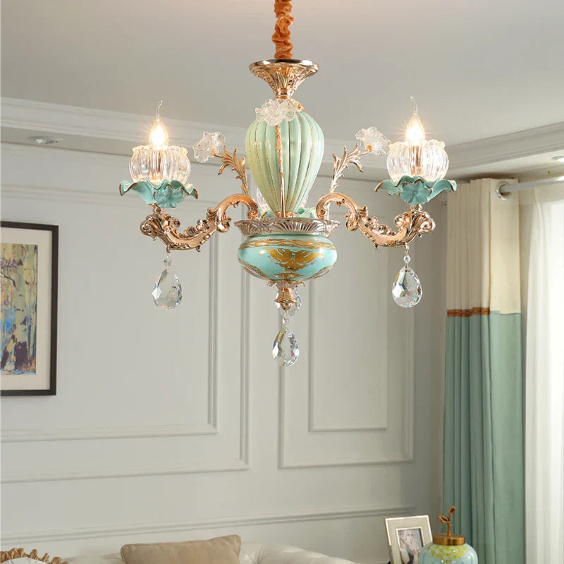 Gold and turquoise European floral ceramic iron chandelier with crystal bulb holders and hanging pendants.