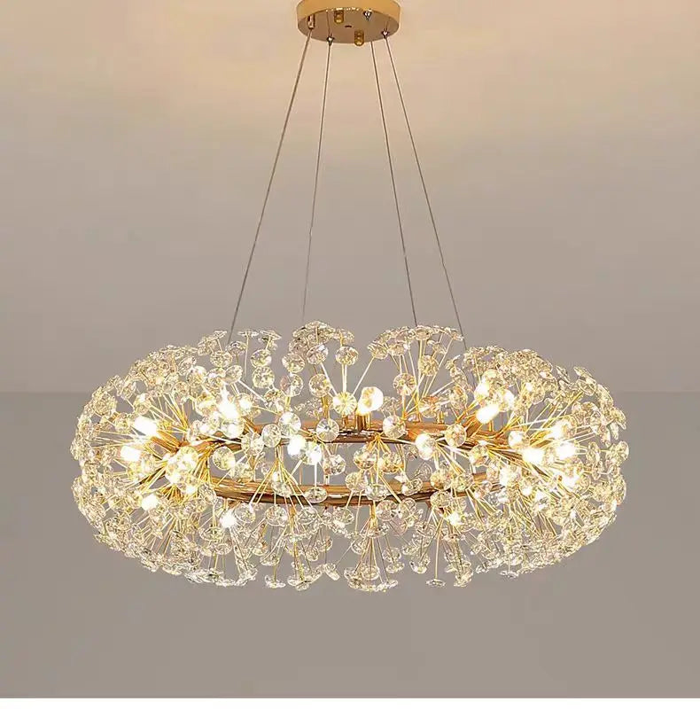 Gold-finished chandelier with LED lighting, dandelion-like crystals, and slim suspension cables.