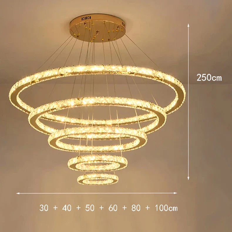 Six dimmable circular LED rings in graduated sizes suspended at varied heights, largest 100cm.