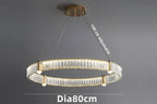 Gold crystal chandelier with LED rings, visible bulbs, and adjustable wires; modern product-focused design.