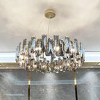 Modern crystal LED chandelier with prisms on thin wires, gold circular base, elegant lighting.