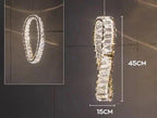 Oval vertical LED chandelier with clear crystals, gold accents; elegant, modern lighting fixture.