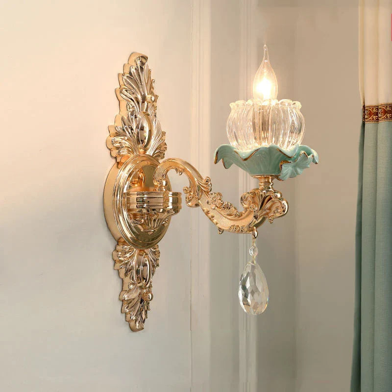 Gold ornate chandelier with glass flower lamps, green detailing, and hanging crystal accents.
