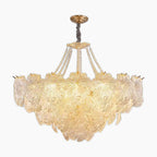Maison Ornate chandelier with layered golden glass leaf petals and gold-finished metal, suspended elegantly.