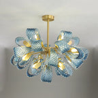 Curved textured blue glass forms a floral starburst LED chandelier with golden accents.