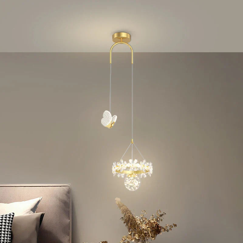 Maison Ornate Minimalist crystal ball pendant light features gold mount, butterfly accent, and sparkling orb.