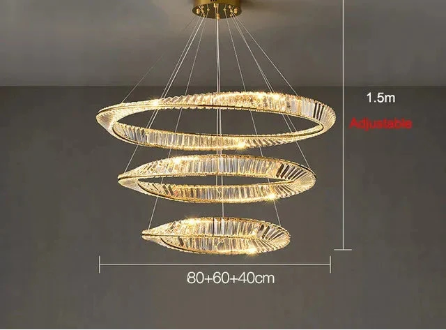 Gold modern crystal chandelier with three illuminated rings, suspended by wires and height adjustable.
