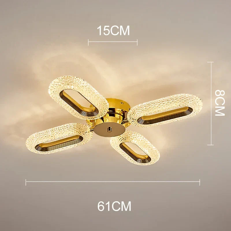 Gold-finished LED chandelier with four oval crystal-like loops in a cross pattern, elegant and modern.
