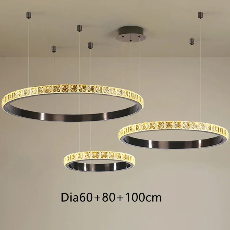 Set of three round Maison Ornate crystal chandeliers with black frames, gold accents, varying diameters.