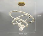 Luxury Maison chandelier with three golden crystal LED rings and four glass balls, 120 cm high.