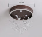 Modern Crystal Ball Chandelier with a round brown base and clear glass birds beneath LED bulbs.