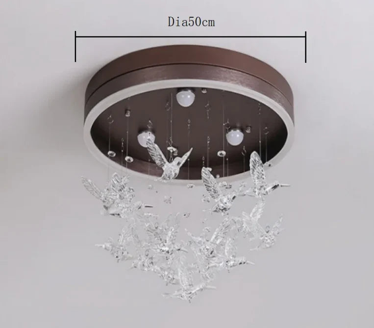 Modern Crystal Ball Chandelier with a round brown base and clear glass birds beneath LED bulbs.