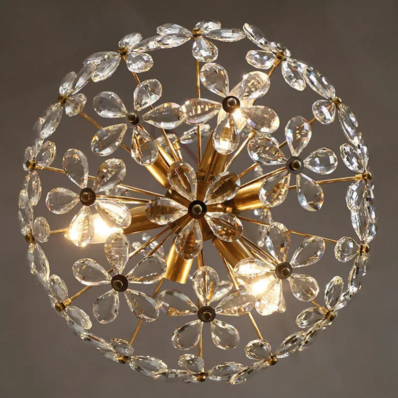 Gold rods and clear crystal petals form a dazzling LED flower chandelier sphere, elegantly dimmable.