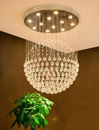 Polished steel chandelier with spherical hanging crystals and LED lights on round ceiling mount.
