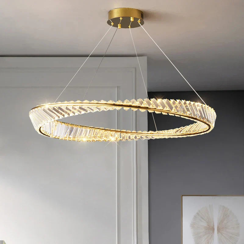 Modern circular gold chandelier with crystals, four-wire suspension, LED-lit for warm elegant illumination.