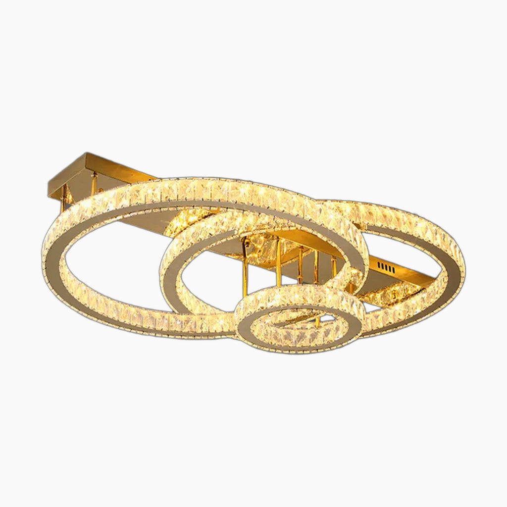 Three interlocking crystal rings form a modern chandelier, suspended from a rectangular gold base.