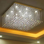 Square chrome chandelier with cascading crystal balls, LED lights emitting bright white and warm yellow glow.
