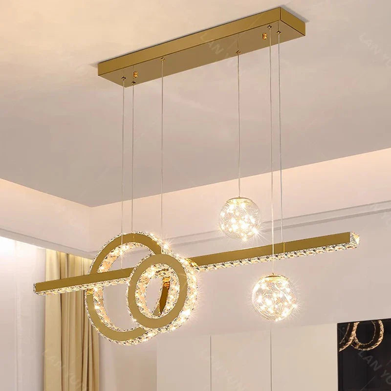 Geometric modern crystal chandelier with three spherical lights suspended by thin wires; elegant style.