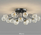 Modern chandelier with clear glass spheres, black branching arms, and LED star accents, 80cm diameter.