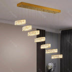 Six rectangular crystal LED chandelier lights hang in a gold mount's descending staircase pattern.