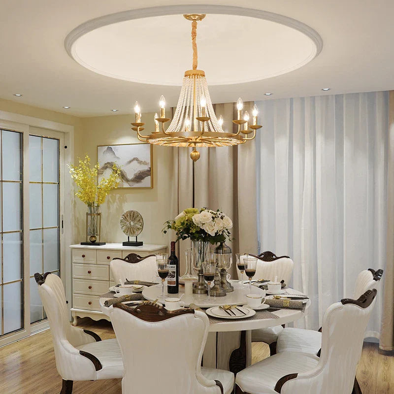 Maison Ornate Elegant Crystal Chandelier with tassels and gold details, sparkling above, beautifully crafted.
