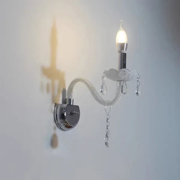 Elegant Nordic Baroque chandelier with curved glass tubes and candle-like bulbs, casting ornate shadows.