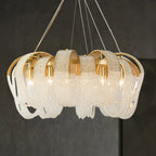 Gold and crystal spiral chandelier with ornate looping bands and multi-wire suspension. Modern, luxurious design.