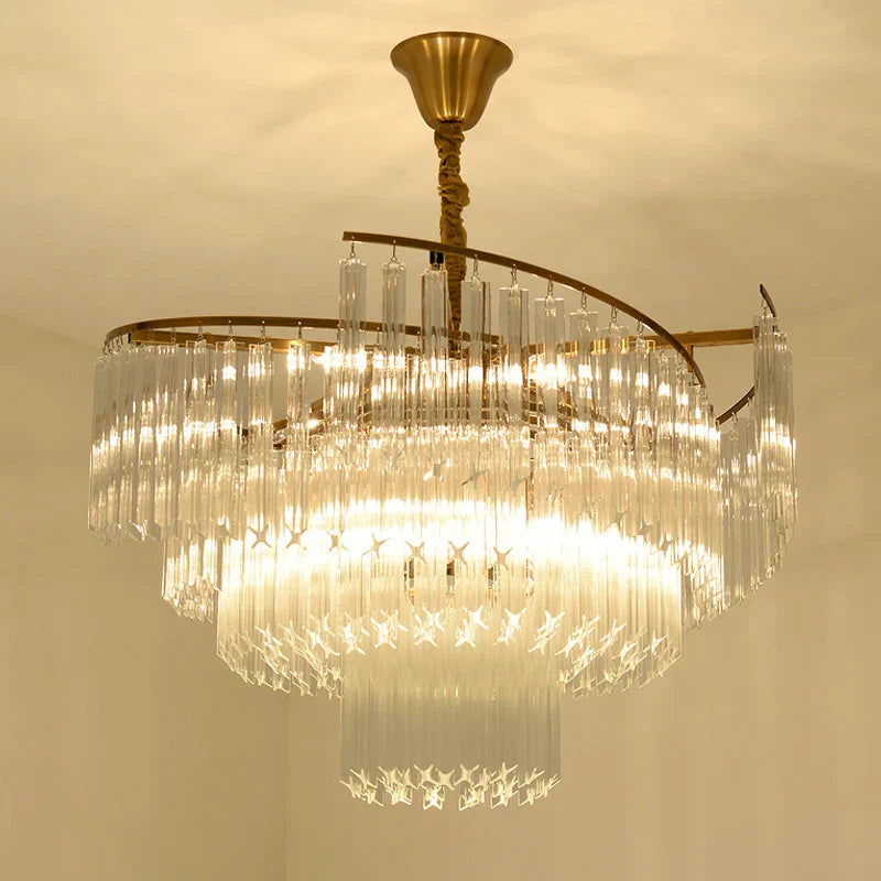 Elegant crystal pendant chandelier by Maison Ornate with cascading glass prisms and brass frame, bright LED glow.