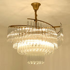 Elegant crystal pendant chandelier by Maison Ornate with cascading glass prisms and brass frame, bright LED glow.
