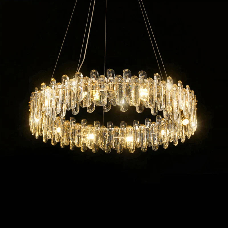 Circular chandelier with ornate golden frame, clear crystal prisms, and multiple warm-hued lights hanging.