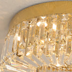 Close-up of gold-base chandelier with rectangular crystal prisms and warm integrated LED lighting.