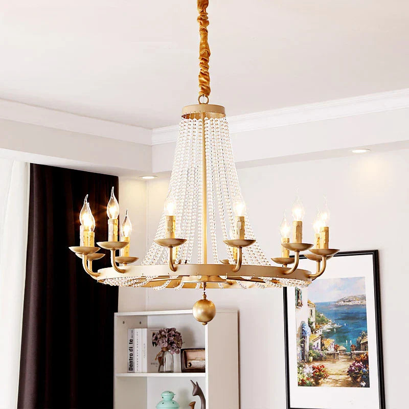 Ornate elegant crystal chandelier featuring gold details and tassels, suspended from the ceiling.