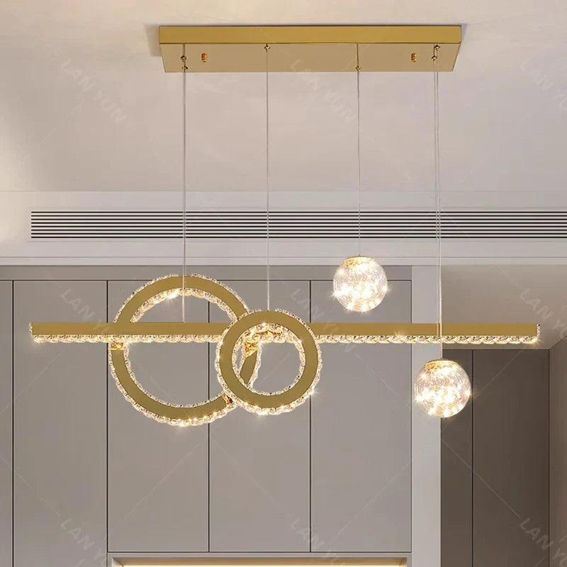 Three illuminated rings with hanging crystal spheres form this elegant, modern chandelier centerpiece.