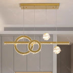 Three illuminated rings with hanging crystal spheres form this elegant, modern chandelier centerpiece.