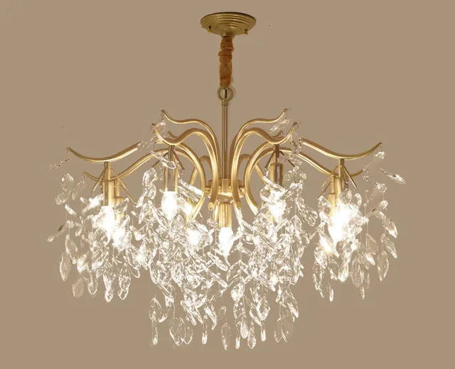 Gold-finished LED chandelier with curved arms and clear leaf-shaped crystals, sparkling contemporary design.