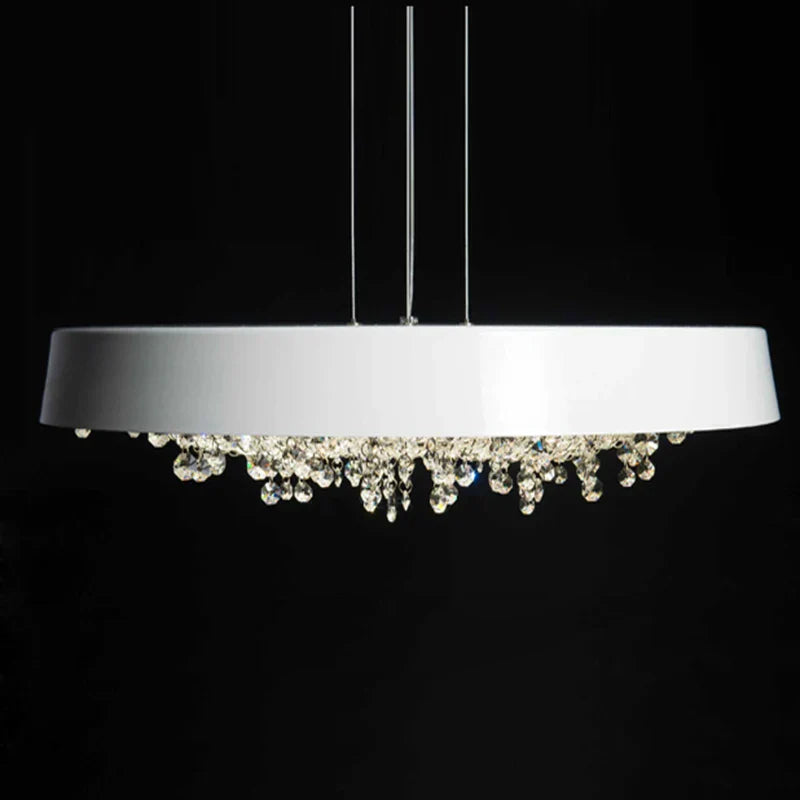 Modern white circular LED chandelier with sparkling crystal accents, suspended by thin wires.