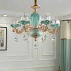 Turquoise and gold floral chandelier with six ornate arms, crystal drops, and glass lampshades.