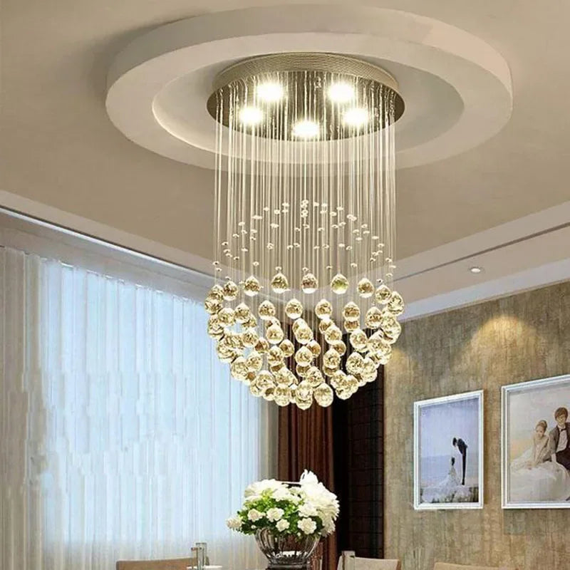 Modern spherical crystal chandelier with spiral hanging glass crystals and polished steel LED mount.