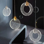 Four crystal pendant chandeliers by Maison Ornate with circular textured shades and metallic accents.